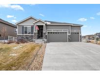 Charming home featuring gray siding, stone accents, a three car garage, and well maintained front yard at 5723 Berry Ridge Way, Castle Rock, CO 80104