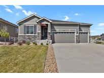 Charming home featuring stone accents, a three-car garage, and an American flag at 5723 Berry Ridge Way, Castle Rock, CO 80104