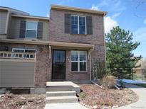 Charming two-story townhome featuring a brick facade, secure front door and well-manicured landscaping at 559 Alton Way # E, Denver, CO 80230