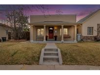 Charming single-story home featuring a covered porch with a swing, bench, and red door at 3929 Shoshone St, Denver, CO 80211