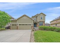 Charming two-story home featuring a three-car garage and well-manicured lawn at 6461 S Ider St, Aurora, CO 80016