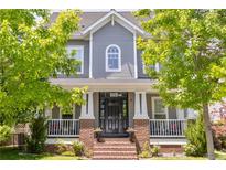 Charming two-story home with gray siding, white trim, and a welcoming brick front porch at 3261 Trenton St, Denver, CO 80238