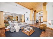 Bright, open-concept living room with wood floors, modern furnishings, and easy access to the kitchen and entry at 1070 Cypress Way, Castle Rock, CO 80108