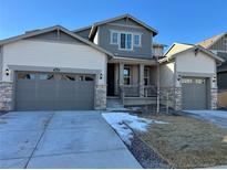 Inviting home featuring a three car garage, covered porch and stone accents at 2598 Knobbie Cir, Castle Rock, CO 80109