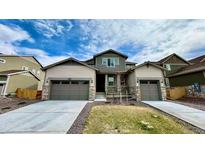 Charming two-story home featuring a manicured lawn and a two-car garage at 2598 Knobbie Cir, Castle Rock, CO 80109