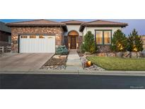 Charming home featuring a brick exterior, well-manicured landscaping, and a welcoming entrance at 10660 Winding Pine Pt, Highlands Ranch, CO 80126
