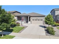 Charming single-Gathering home with well-manicured lawn, a two-car garage, and inviting front porch at 802 Eva Peak Dr, Erie, CO 80516