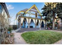 Charming two-story home with a wrap-around porch and well-manicured lawn at 2431 N Ogden St, Denver, CO 80205