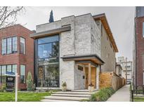 Modern home featuring a light stone facade, a large black-framed window and professional landscaping at 1717 Irving St, Denver, CO 80204