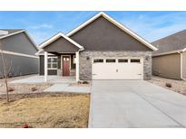 Charming home featuring stone accents, a two-car garage, and a well-maintained front yard at 308 Josef Cir, Fort Lupton, CO 80621