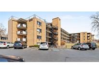 Multi-level brick apartment building with balconies and parking at 800 W Belleview Ave # 201, Englewood, CO 80110