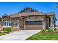 Stone-accented home with a brown two-car garage door and well-manicured front yard at 25019 E Alder Dr, Aurora, CO 80016