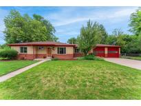 Charming ranch-style home featuring a well-maintained lawn and inviting red garage doors at 8675 Calvin Dr, Arvada, CO 80002