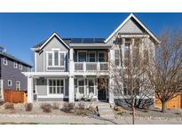 Charming two-story home featuring a spacious front porch with seating and solar panels at 9575 E 3Rd Pl, Denver, CO 80230