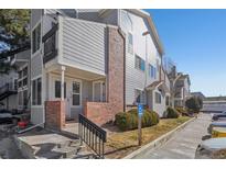 Attractive townhome featuring gray siding, brick accents, and convenient accessible parking in a well-maintained complex at 5550 W 80Th Pl # 1, Arvada, CO 80003