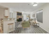 Bright living room with stone fireplace and TV, seamlessly connecting with the kitchen counter seating at 5550 W 80Th Pl # 1, Arvada, CO 80003