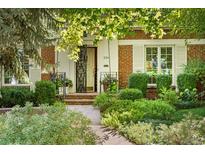 Charming brick home with a well-manicured front yard and inviting walkway leading to the front door at 334 Ivy St, Denver, CO 80220