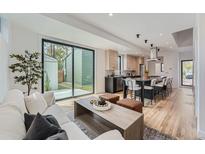 Bright and airy living room featuring hardwood floors and a seamless flow to the modern kitchen and backyard access at 1928 W 41St Ave, Denver, CO 80211