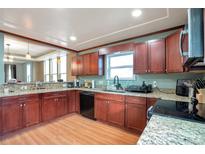 Updated kitchen featuring stainless steel appliances, granite countertops, and wood-look flooring at 14050 W 8Th Ave, Golden, CO 80401