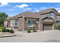 Charming home featuring a stone and siding exterior, well-manicured landscaping, and an attached two-car garage at 14916 E Crestridge Pl, Centennial, CO 80015