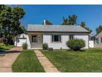 Charming home with white siding, gray roof, and green lawn on a sunny day at 3311 S Eudora St, Denver, CO 80222