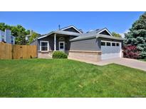 Charming gray single-Gathering home featuring a well-maintained lawn and attached two-car garage at 690 W Jamison Cir, Littleton, CO 80120