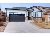 Charming single-Gathering home with stone accents, dark trim, and a two-car garage at 7470 Blue Water Ln, Castle Rock, CO 80108