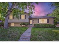 Charming exterior of a two-story home with well-maintained lawn and mature tree at 11797 Keough Dr, Northglenn, CO 80233