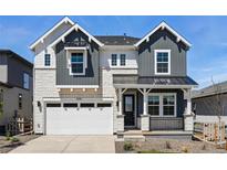 Charming two-story home featuring stone accents, dark gray siding, a black metal roof, and well-manicured landscaping at 7291 Prairie Sage Pl, Littleton, CO 80125