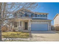 Charming two-story home featuring stone accents, a covered porch, and an attached two-car garage at 15786 Randolph Pl, Denver, CO 80239