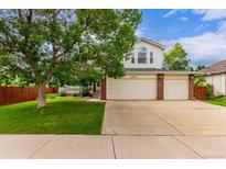 Charming two-story home with a well-maintained lawn and a spacious three-car garage at 12825 Forest Way, Thornton, CO 80241