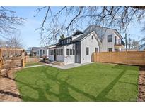 Landscaped backyard featuring a well-maintained lawn, modern fence, and stylish exterior of the home at 4144 Depew St, Denver, CO 80212