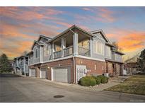 Multi-level townhome showcasing a mix of brick and siding, a private balcony, and attached garage bays at 74 Whitehaven Cir, Highlands Ranch, CO 80129