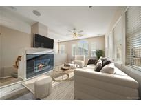 Cozy living room featuring a fireplace, large windows, and neutral decor for a warm and inviting atmosphere at 74 Whitehaven Cir, Highlands Ranch, CO 80129