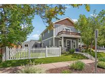 Charming two-story home with a balcony, gray siding, a white picket fence and well maintained landscaping at 4603 W 33Rd Ave, Denver, CO 80212