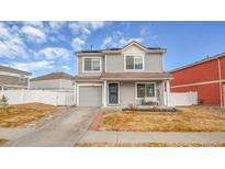 Two-story house with gray siding, attached garage, and a small front yard at 5556 Flanders Way, Denver, CO 80249