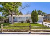 Charming single-story home with a well-manicured lawn, mature trees, and inviting curb appeal at 7930 Poplar St, Commerce City, CO 80022