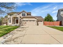 Charming two-story home with a three-car garage and well-maintained front lawn and a brick and siding exterior at 9411 La Quinta Way, Lone Tree, CO 80124