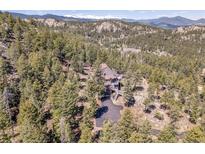 Secluded mountain home nestled amongst tall pine trees with a private driveway and breathtaking mountain views at 6574 Olympus Dr, Evergreen, CO 80439