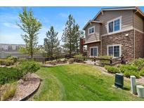 Beautifully landscaped backyard with lush grass, a wooden fence, and mature trees at 22044 E Jamison Pl, Aurora, CO 80016