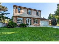 Charming two-story home featuring a well-manicured lawn and a classic brick and siding facade at 8538 W Glasgow Pl, Littleton, CO 80128