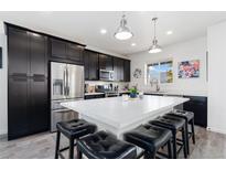 Modern kitchen boasts stainless steel appliances, granite countertops, and an island with seating at 18060 E 106Th Pl, Commerce City, CO 80022