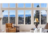 Bright living room with large windows and mountain views at 73 Falcon Hills Dr, Highlands Ranch, CO 80126