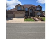 Charming two-story brick home with a well-manicured lawn and an attached two-car garage at 7914 S Clayton Cir, Centennial, CO 80122