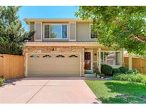 Charming two-story home with a stone facade and a well-maintained front yard and attached garage at 1446 Braewood Ave, Highlands Ranch, CO 80129
