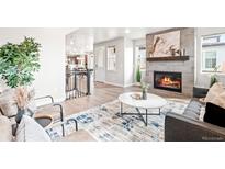Inviting living room with a cozy fireplace, stylish rug, and comfortable seating arrangement at 9700 E 63Rd Pl, Denver, CO 80238