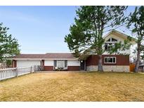 Charming home featuring mixed brick and siding exterior, a well-manicured lawn, and mature trees at 2000 Willow Ln, Lakewood, CO 80215
