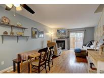 Inviting living room with stone fireplace, hardwood floors, and access to the outdoors at 14211 E Hawaii Cir # A, Aurora, CO 80012