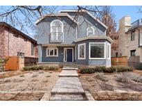 Charming two-story home features a stucco exterior, arched windows, and professionally landscaped front yard at 1034 S Williams St, Denver, CO 80209