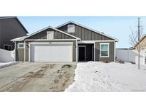 Gray exterior house with white garage door and snowy front yard at 507 Bonneville Ave, Fort Lupton, CO 80621